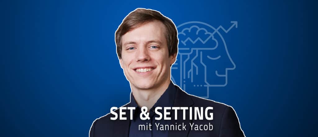 Ein Mann im dunklen Anzug lächelt vor einem blauen Hintergrund mit dem Text „Set & Setting mit Yannick Yacob“ und vertieft sich in die Schnittstellen zwischen Coaching und Therapie.