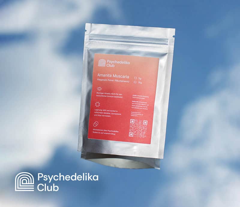 Ein silberner Beutel mit der Aufschrift „Amanita Muscaria“ und dem Logo des Psychedelika Club vor dem Hintergrund eines blauen Himmels.